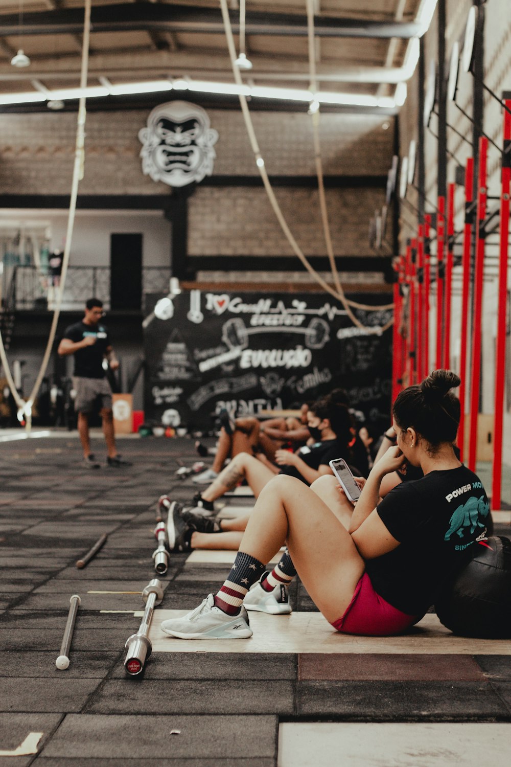 a group of people sitting on the ground in a gym