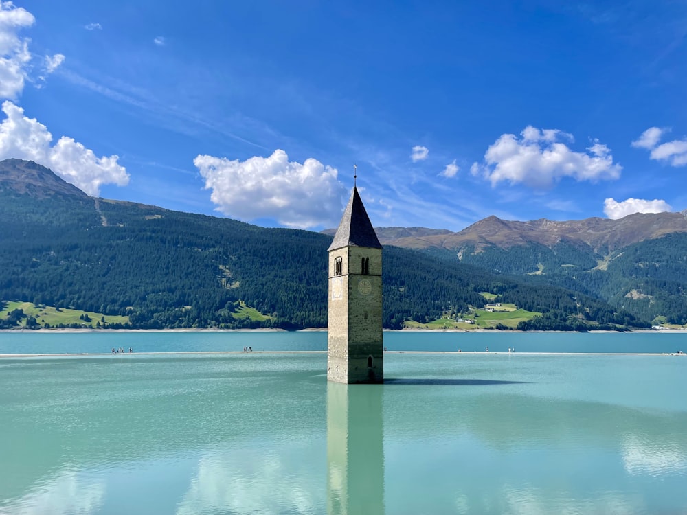 a clock tower sitting in the middle of a lake