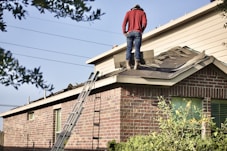 a man standing on the roof of a house