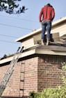 a man standing on the roof of a house