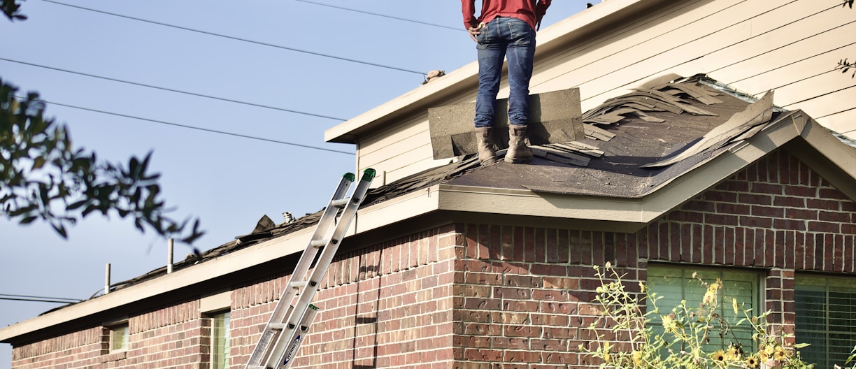 a man standing on the roof of a house