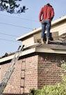 a man standing on the roof of a house