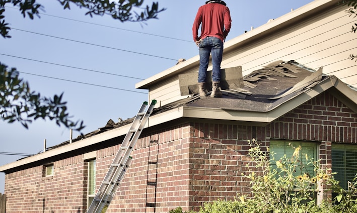 a man standing on the roof of a house