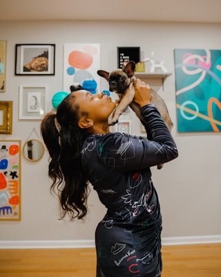 a woman holding a small dog in her arms