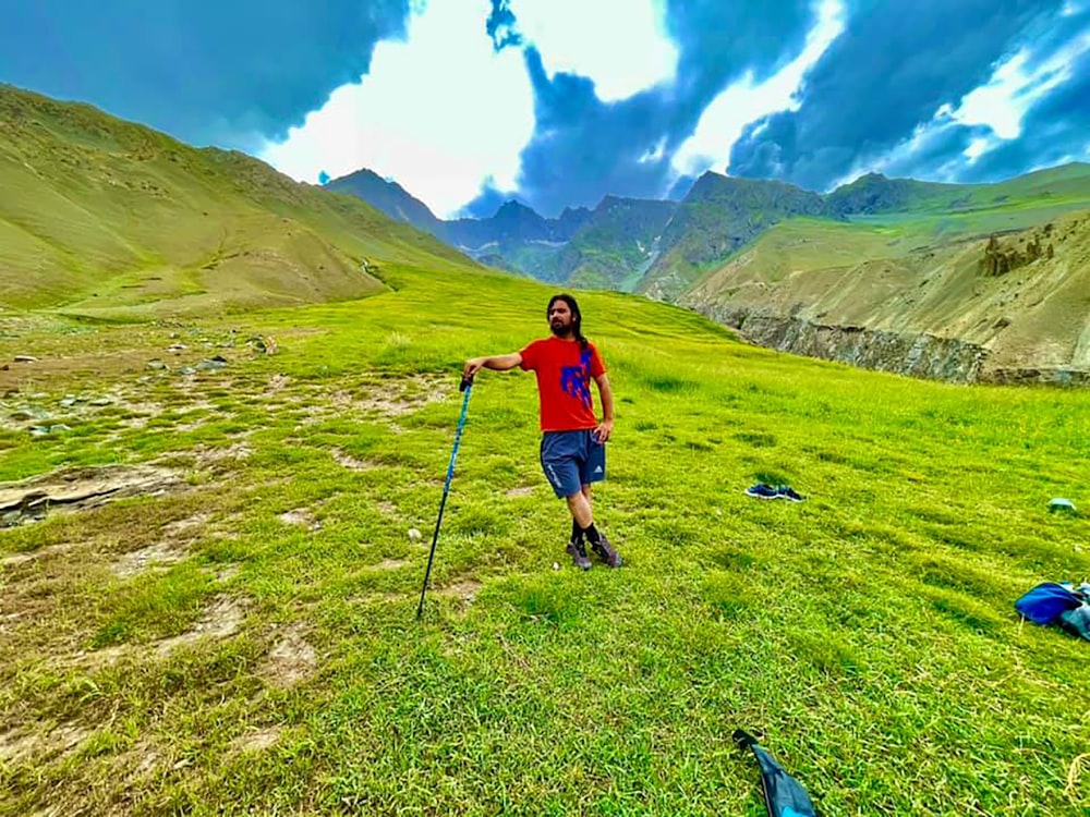 a man standing on top of a lush green field