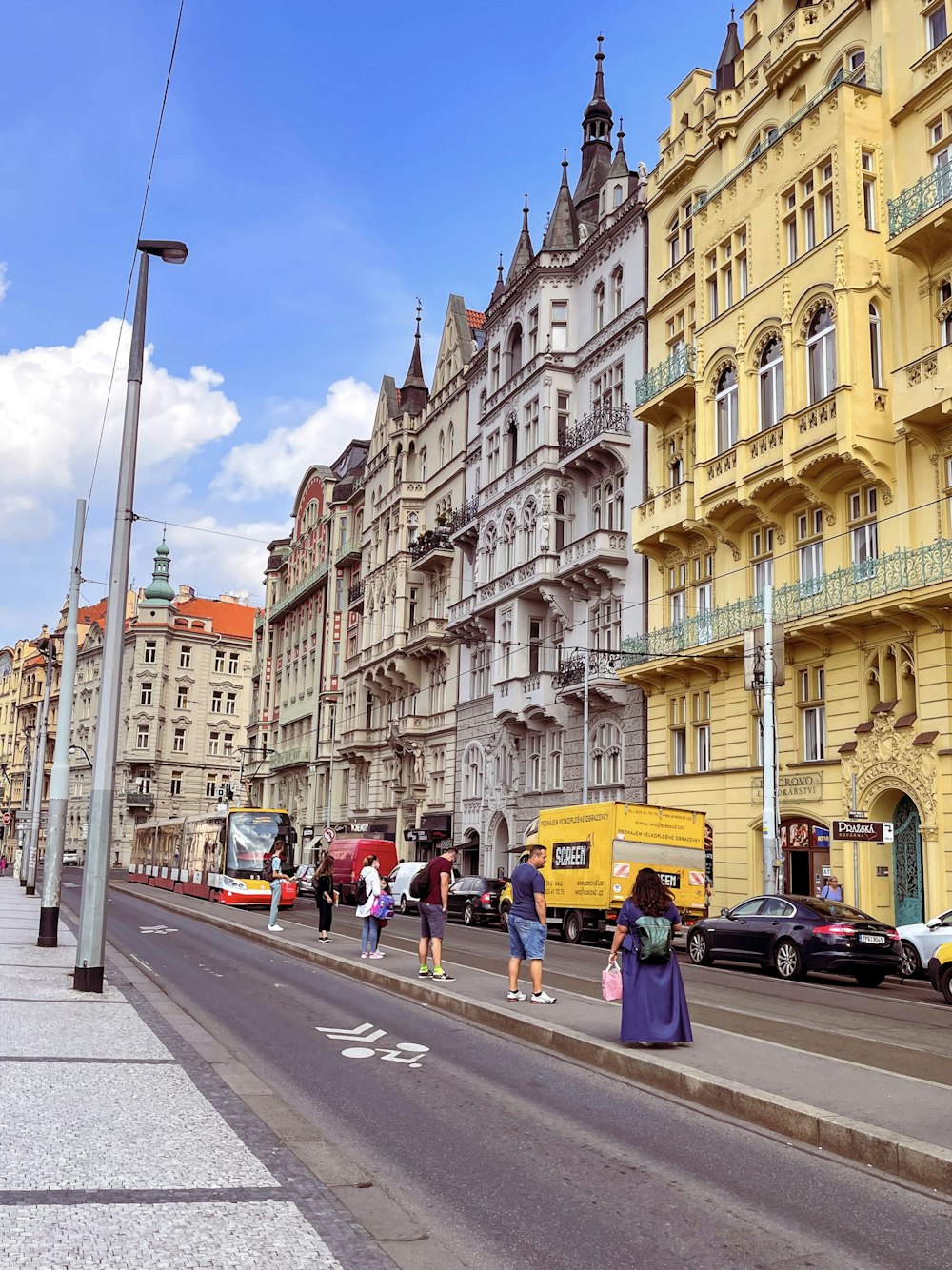 Eine Gruppe von Menschen, die eine Straße neben hohen Gebäuden entlang gehen