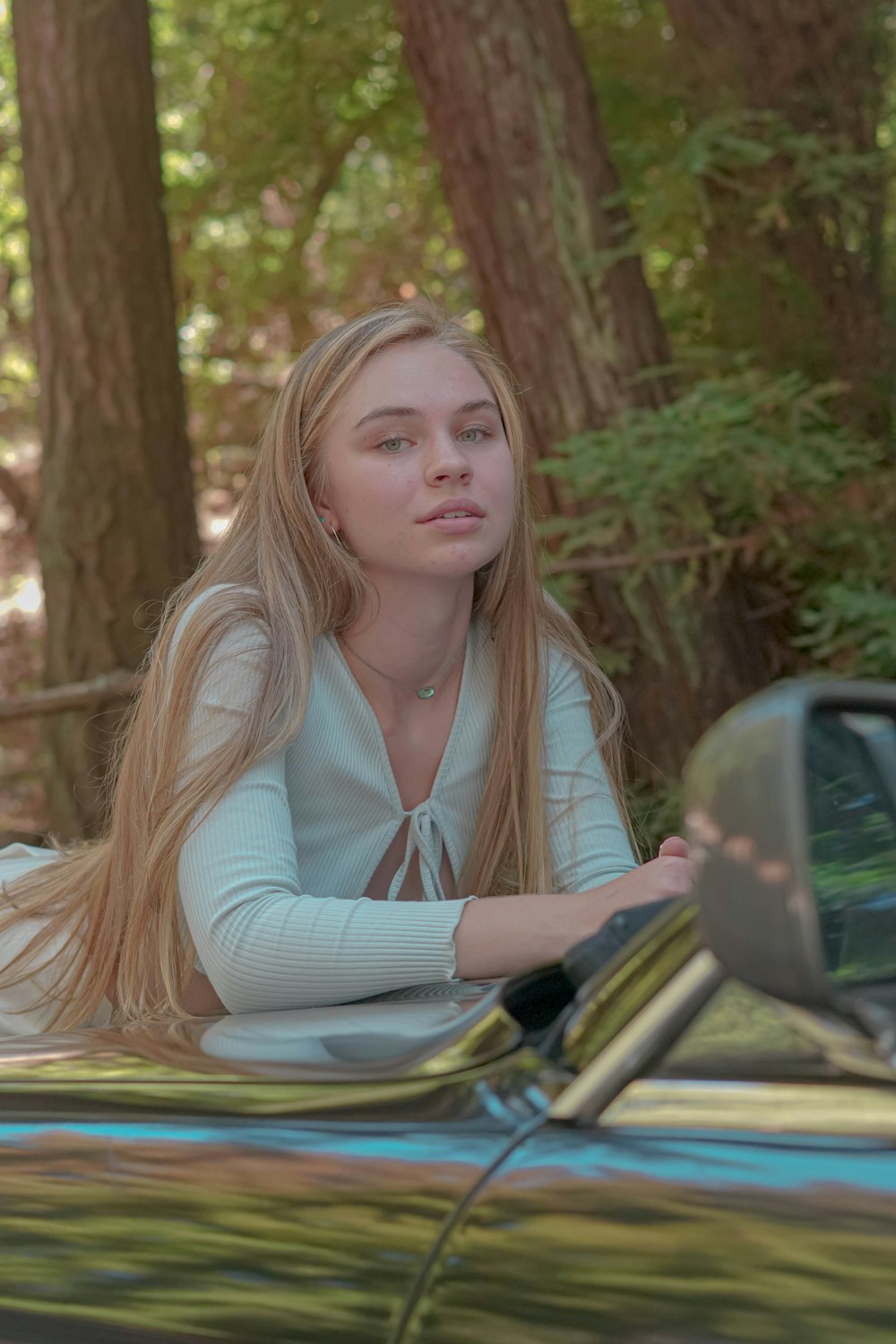 a woman sitting on the hood of a car