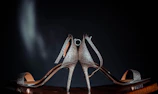 a pair of silver high heeled shoes sitting on top of a table