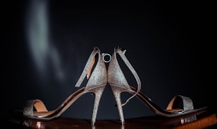 a pair of silver high heeled shoes sitting on top of a table