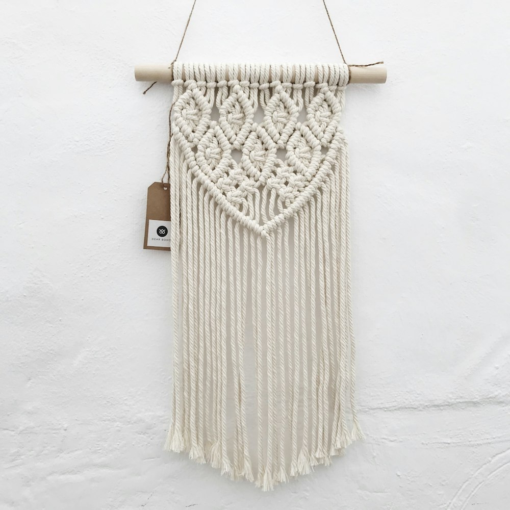a macrame hanging on a wall with a tag