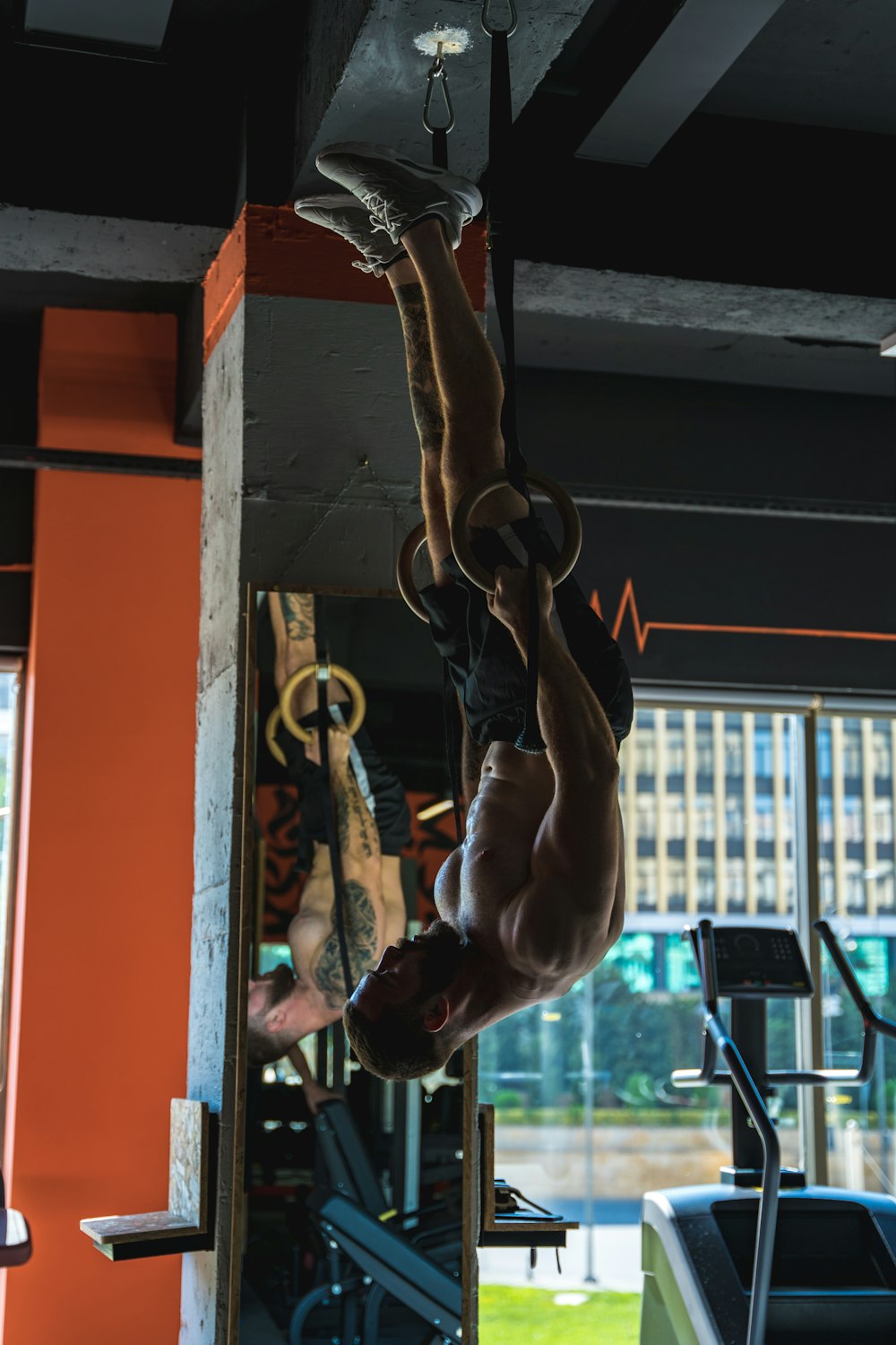 a man hanging upside down in a gym
