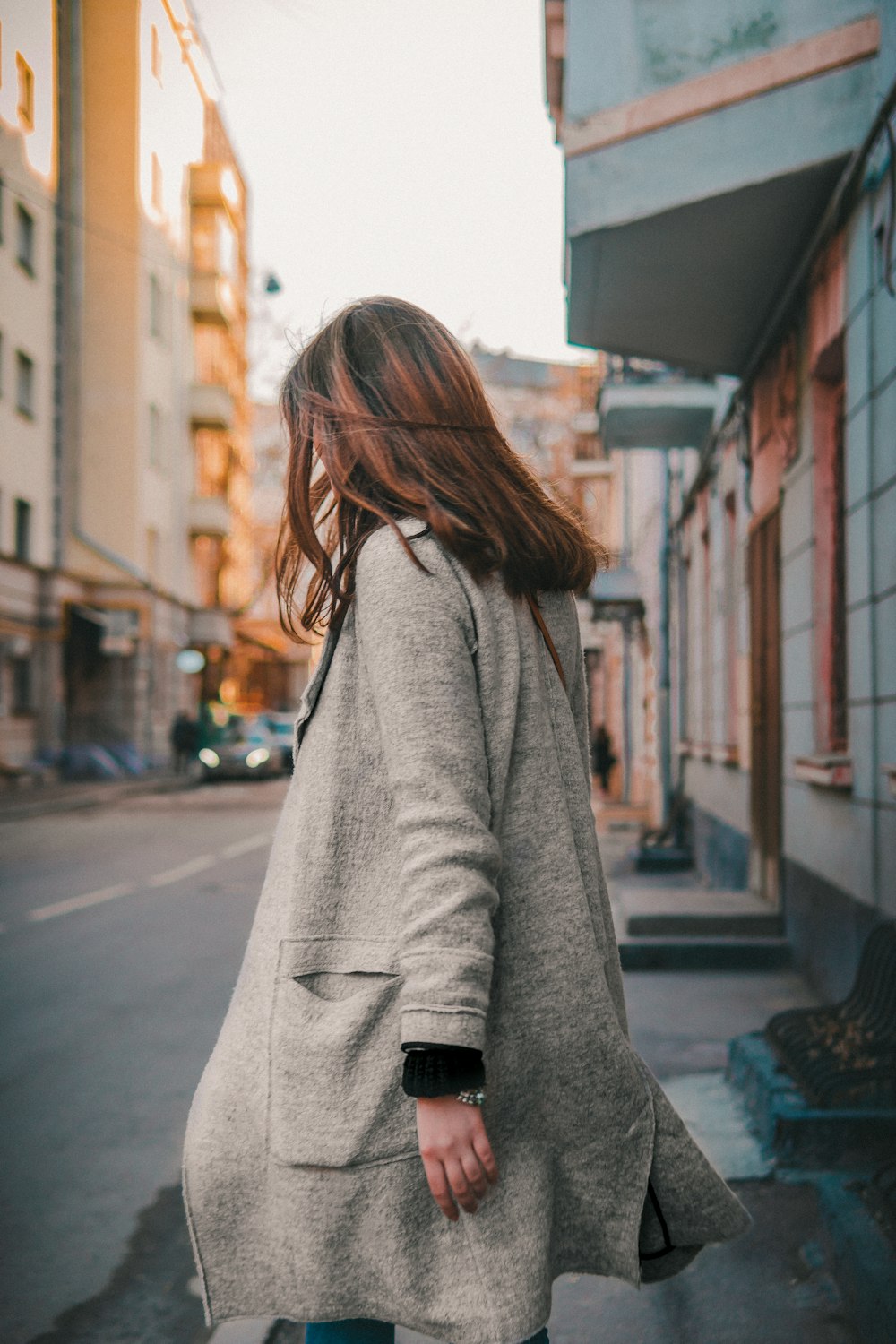 a woman walking down a street holding a handbag