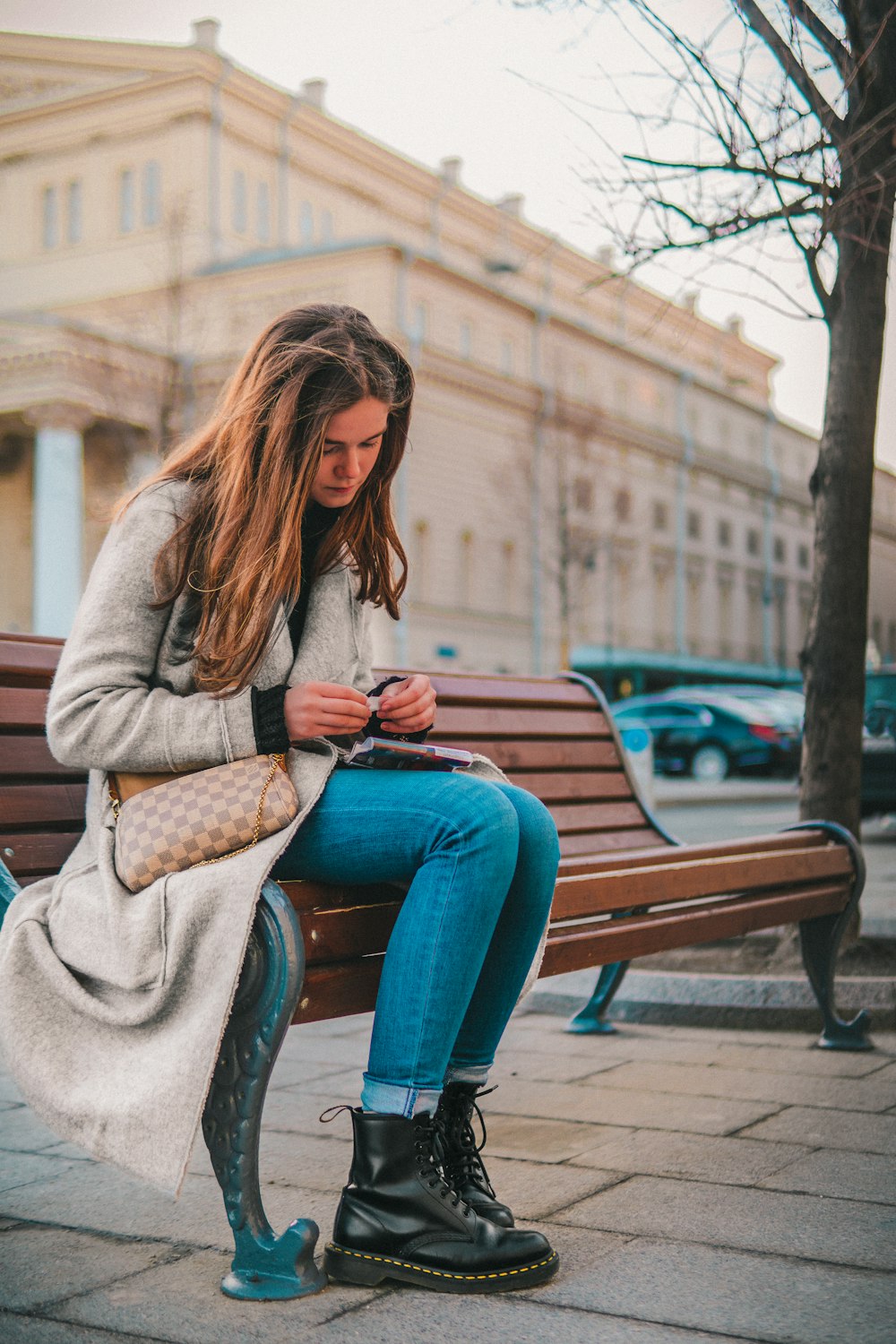 a woman sitting on a bench looking at her cell phone