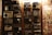 A collection of vintage radios displayed on a wooden wall, each with distinct designs and dials. To the right, an assortment of old album covers is arranged in a grid pattern.