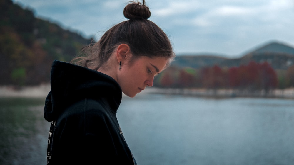 a woman standing next to a body of water