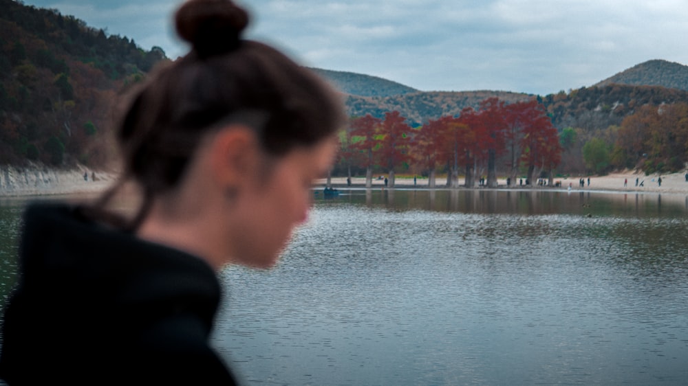 a woman standing in front of a body of water