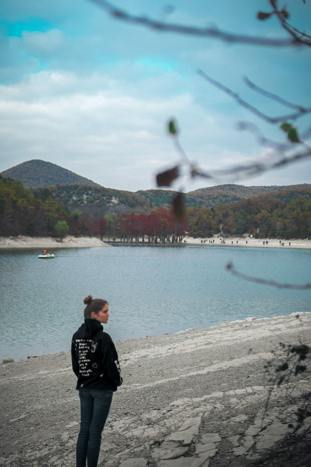 a woman standing on a beach next to a body of water