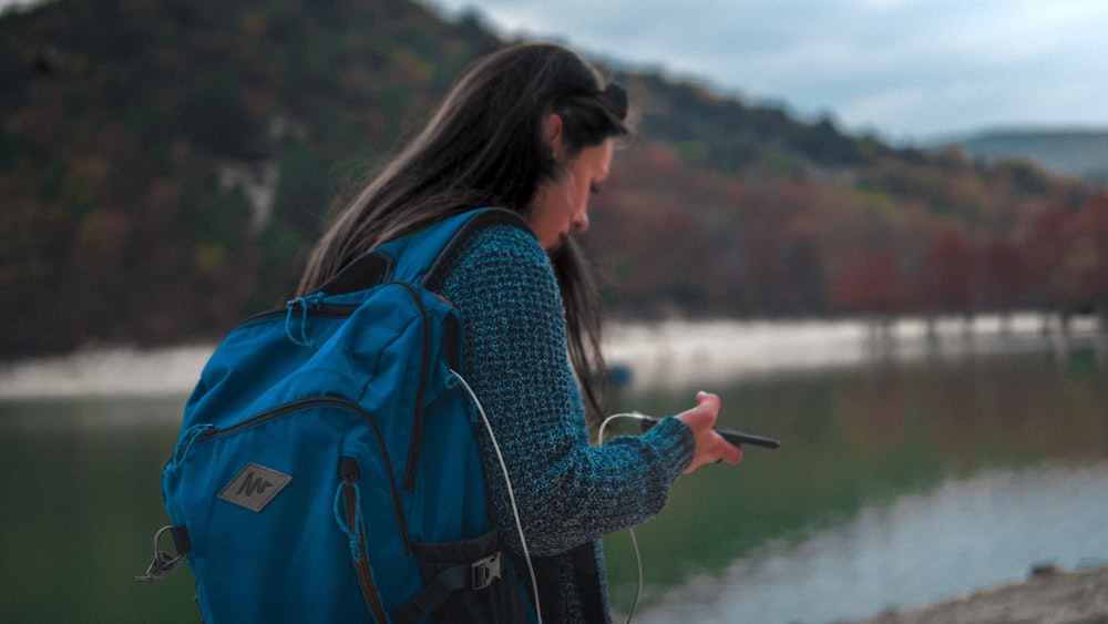 a woman with a backpack looking at her cell phone
