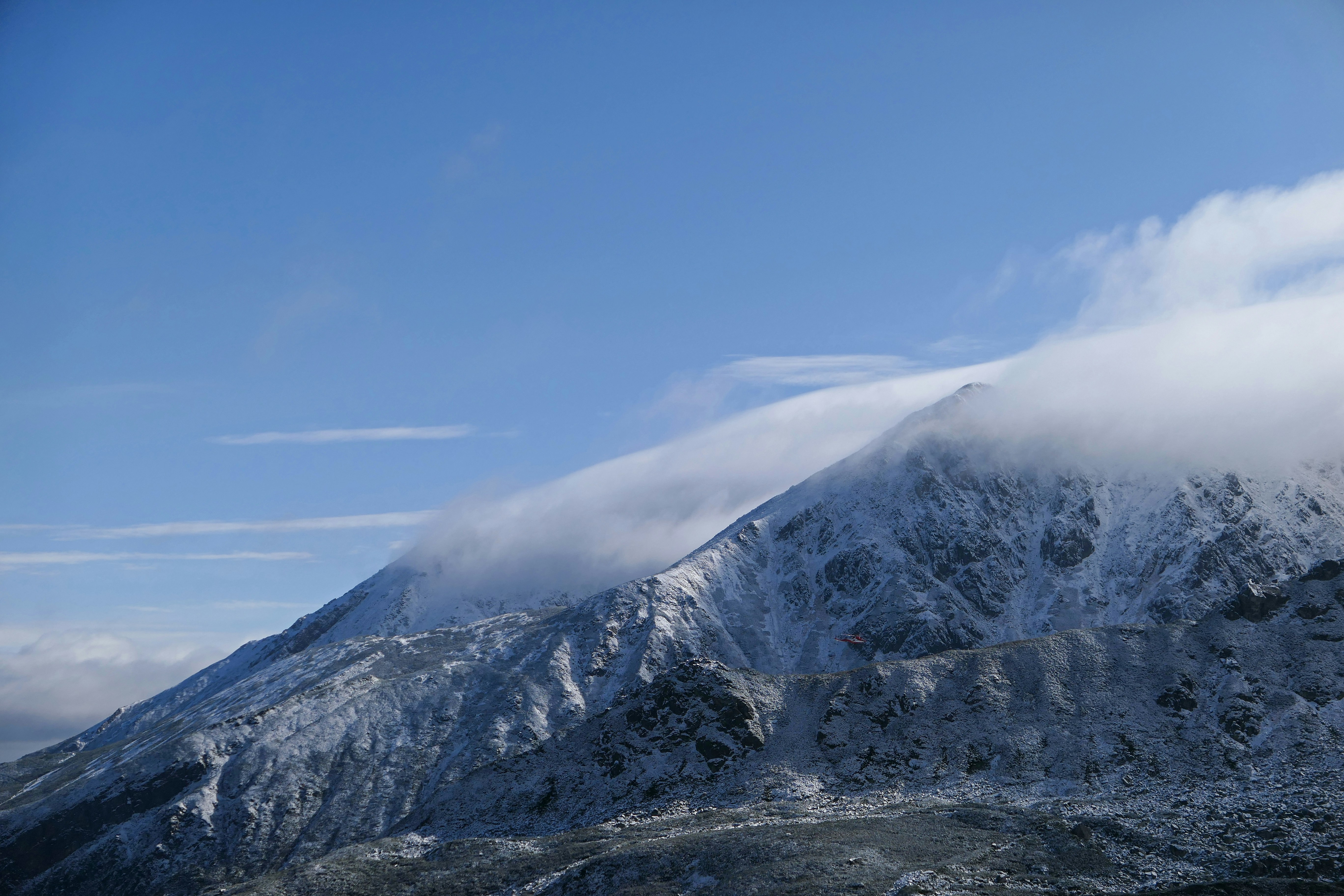 a mountain covered in snow under a blue sky, 