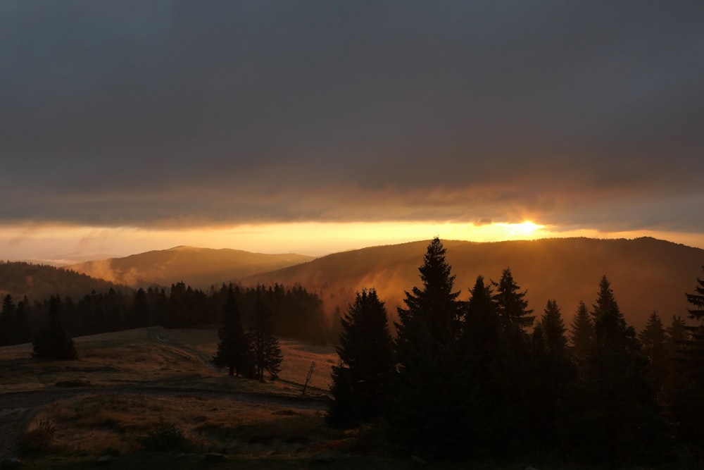 the sun is setting over a mountain range