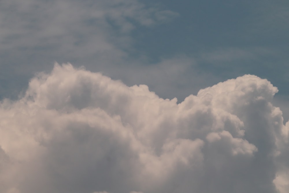 a plane flying in the sky with a lot of clouds