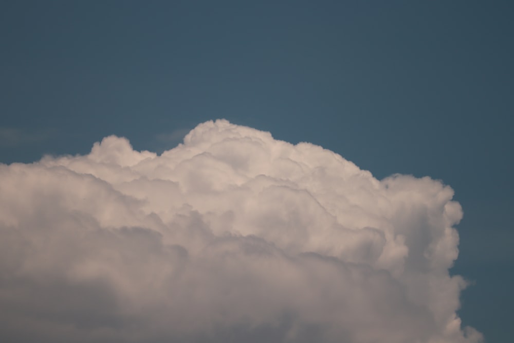 a plane flying through a cloud filled sky