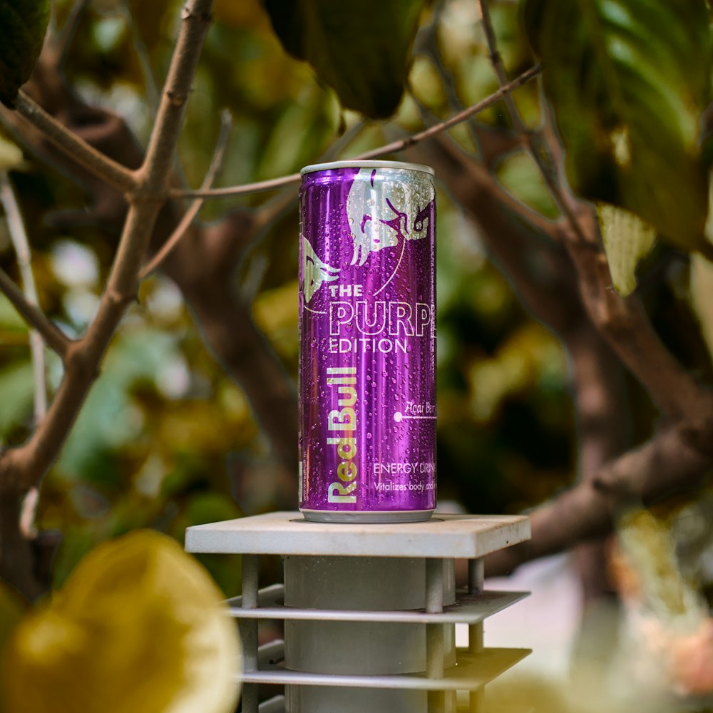 a purple can of beer sitting on top of a metal rack