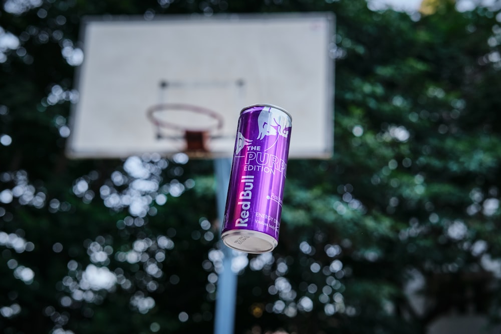 a can of beer is hanging from a basketball hoop