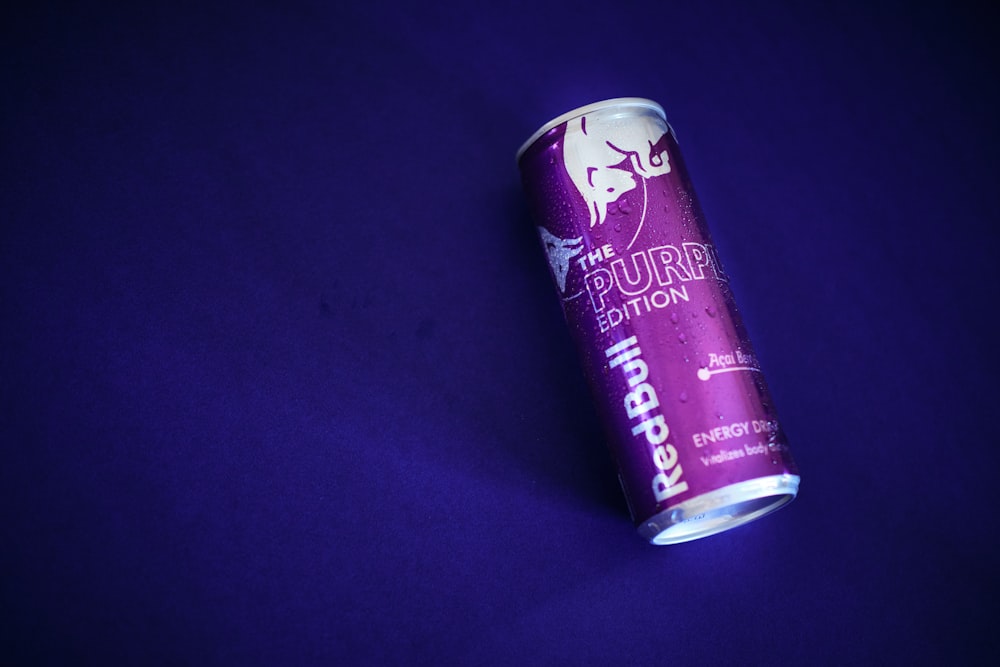 a can of beer sitting on a purple surface