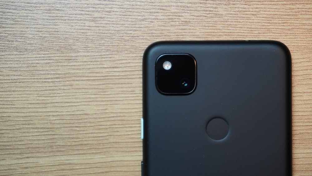 a close up of a cell phone on a wooden surface