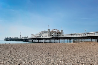 a pier on a beach with a blue sky in the background