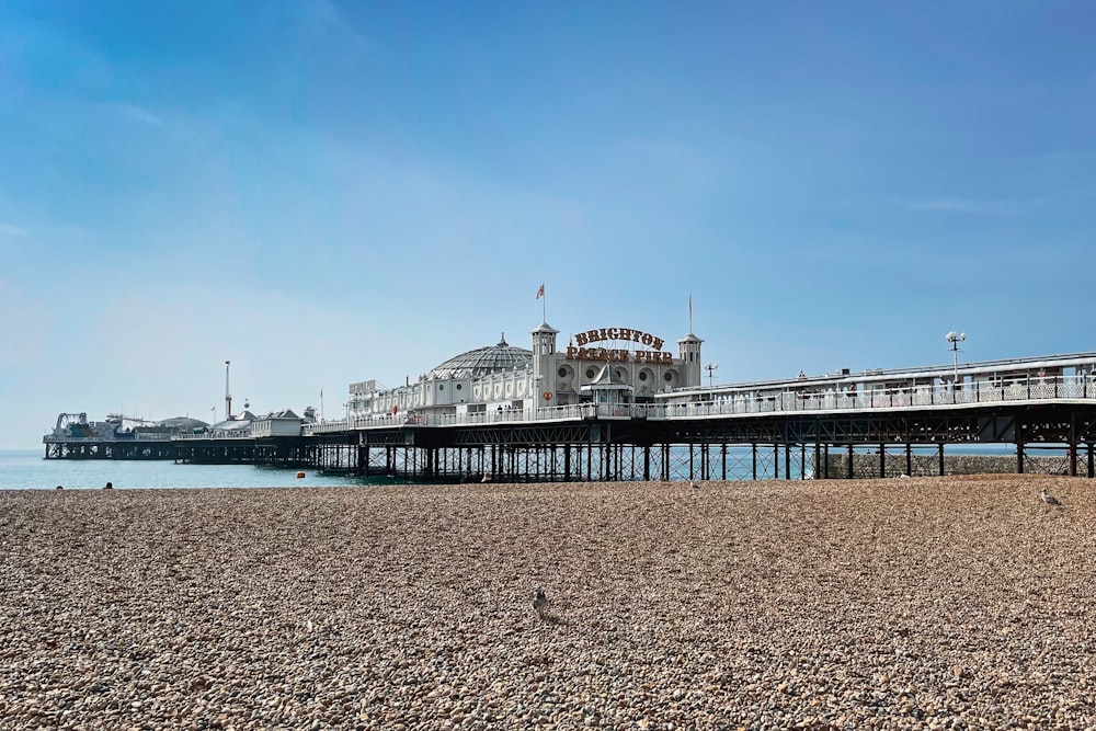 a pier on a beach with a blue sky in the background