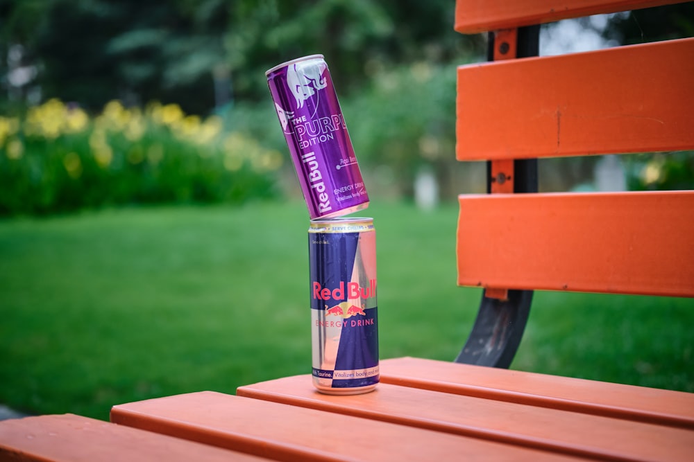 a can of soda sitting on top of a wooden bench