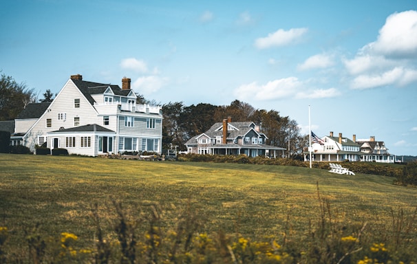 a large white house sitting on top of a lush green field