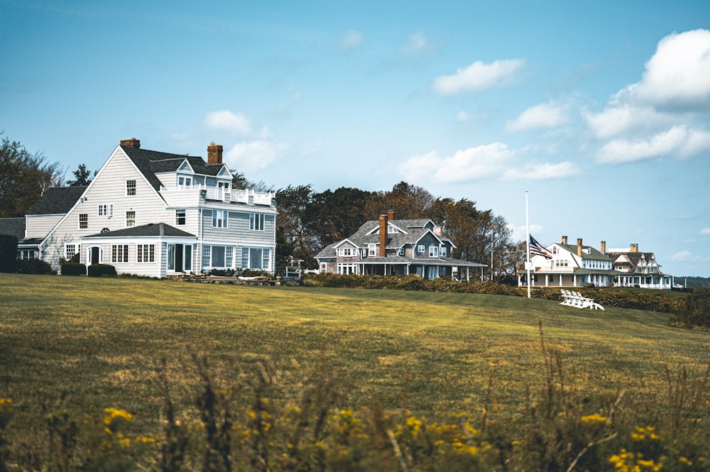 a large white house sitting on top of a lush green field