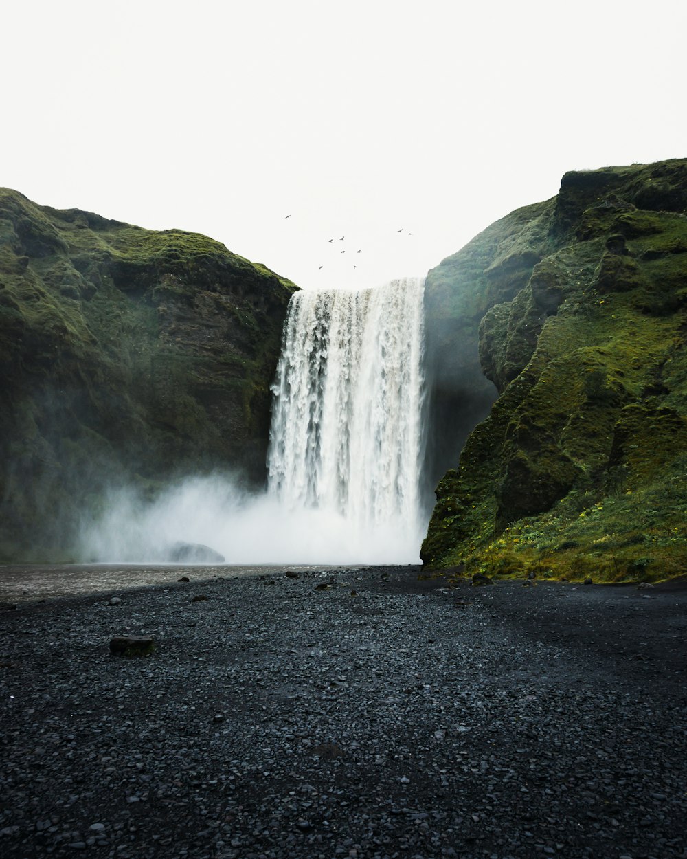 a large waterfall is in the middle of a rocky area