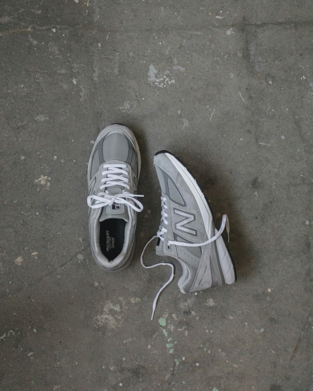 a pair of grey and white tennis shoes