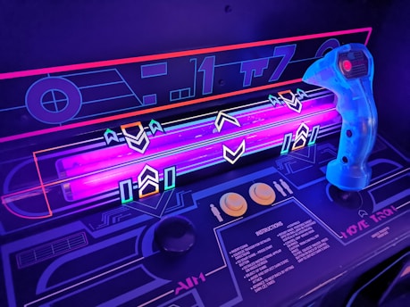 Close-up of a hand interacting with a glowing arcade-style button panel in purple and white.