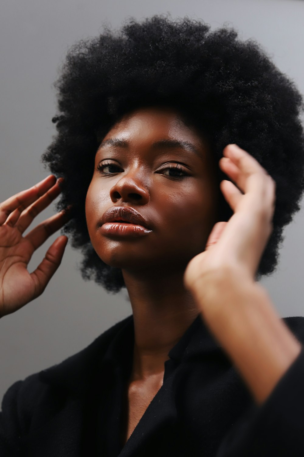 Eine Frau mit einem Afro, der sich die Haare kämmt