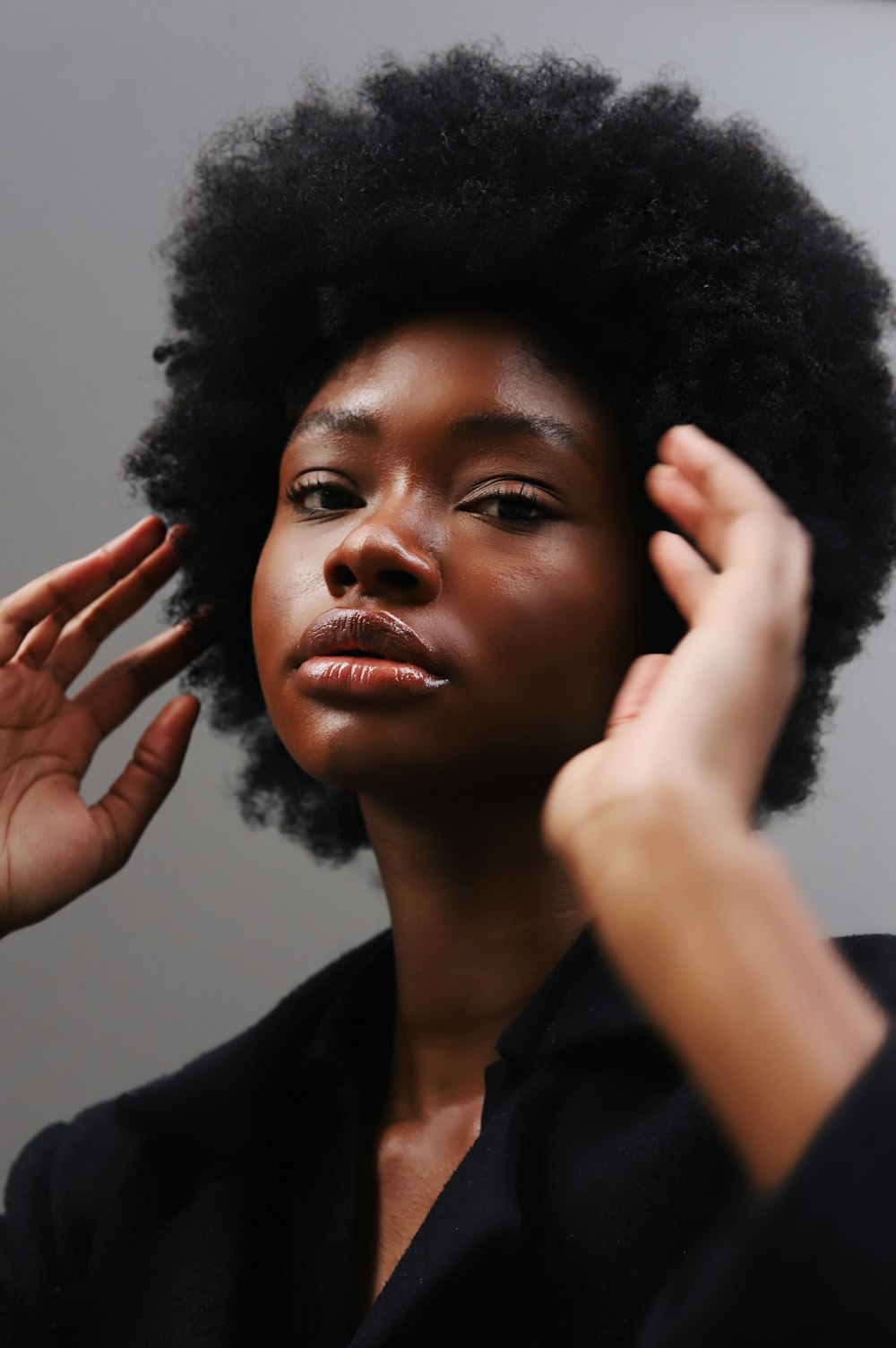 Una mujer con un afro peinándose