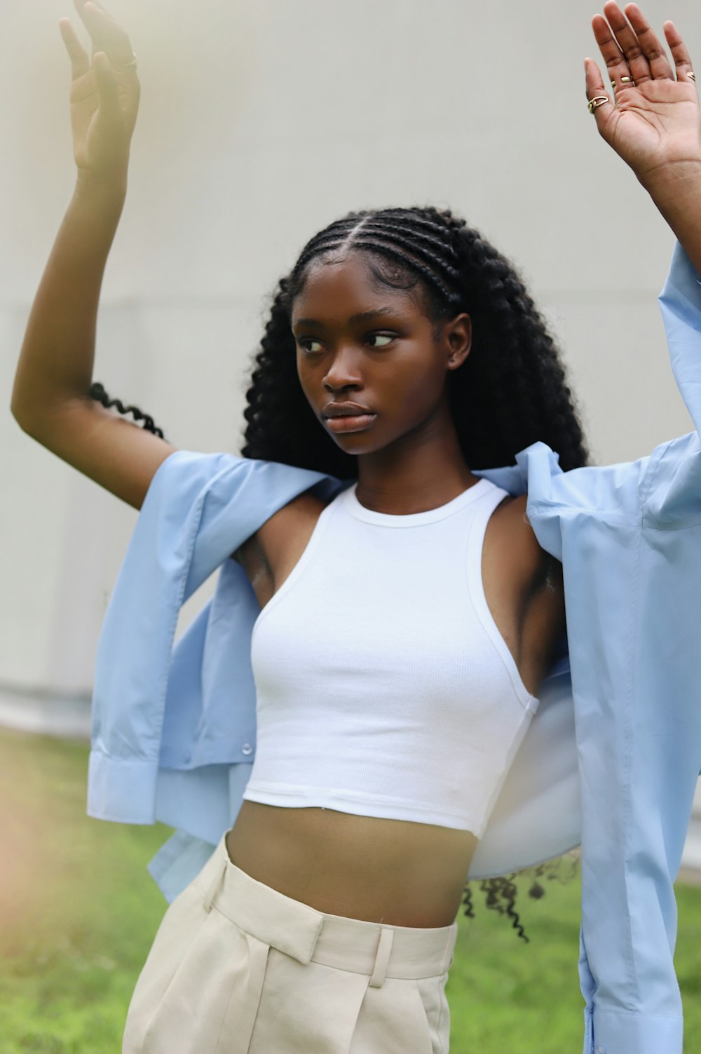 a woman in a white crop top and tan pants