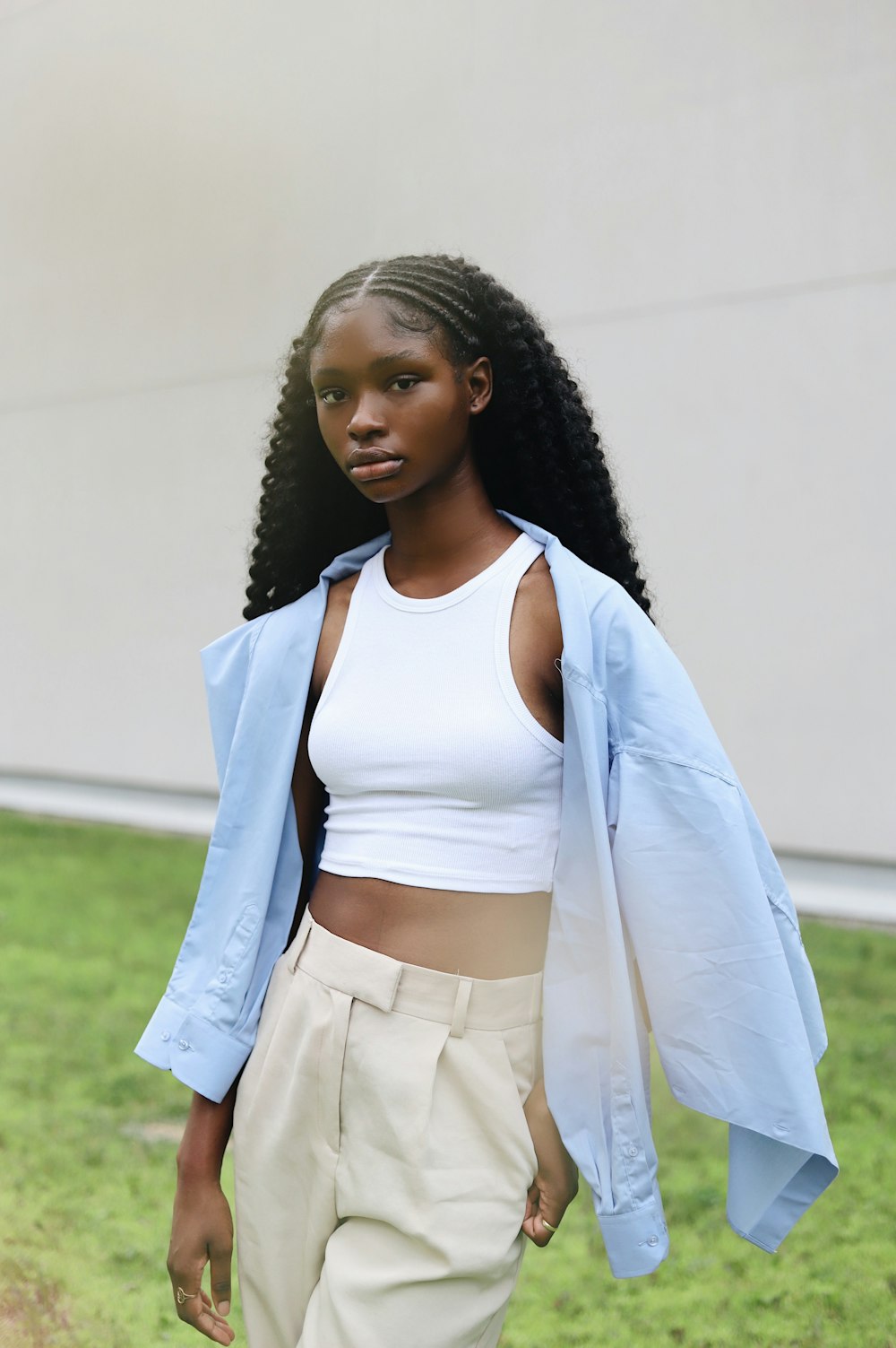 a woman in a white top and tan pants