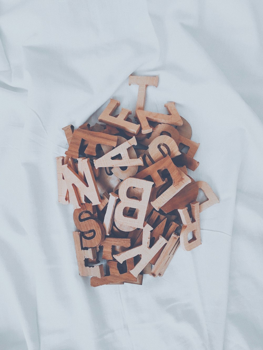 une pile de lettres en bois posée sur un drap blanc