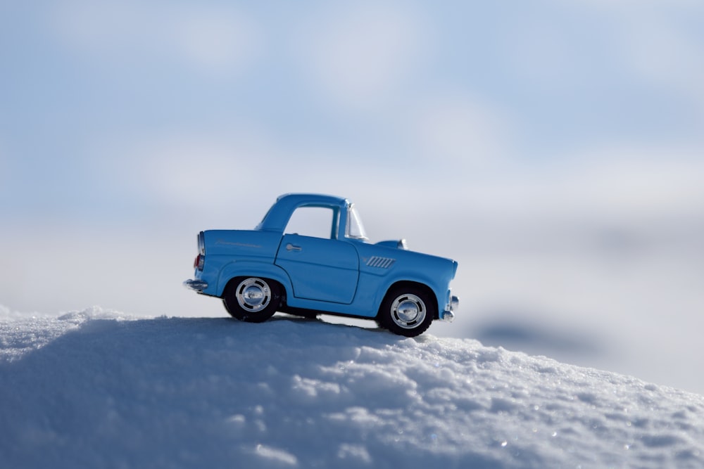 a blue truck is parked on a snowy hill