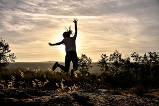 a person jumping in the air with their arms in the air