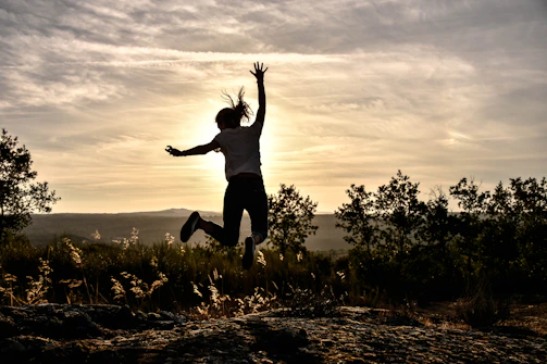 a person jumping in the air with their arms in the air