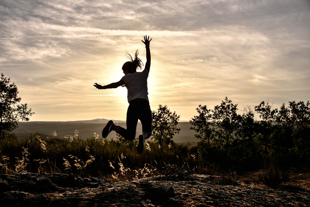 a person jumping in the air with their arms in the air