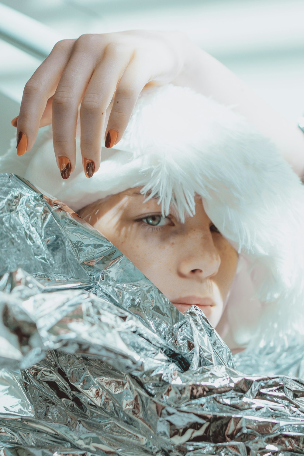 a woman in a white hat is wrapped in tin foil