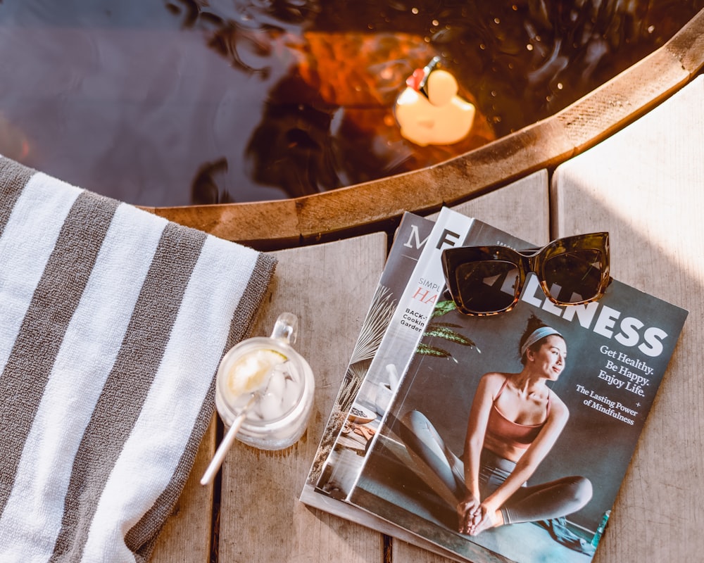 a magazine sitting on top of a wooden table next to a cup of coffee