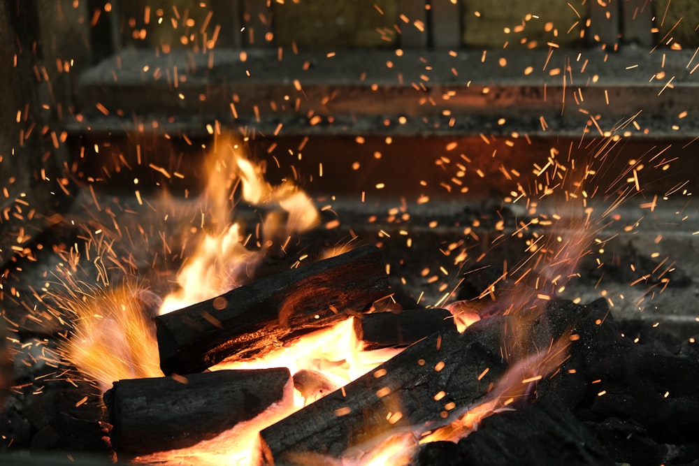 a close up of a fire with sparks coming out of it